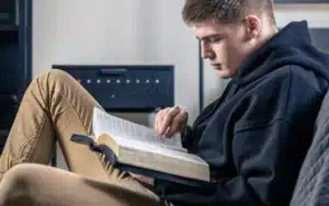 Um jovem rapaz lendo sentado lendo a Bíblia, mostrando uma postura de busca e refúgio no Salmo para ansiedade.